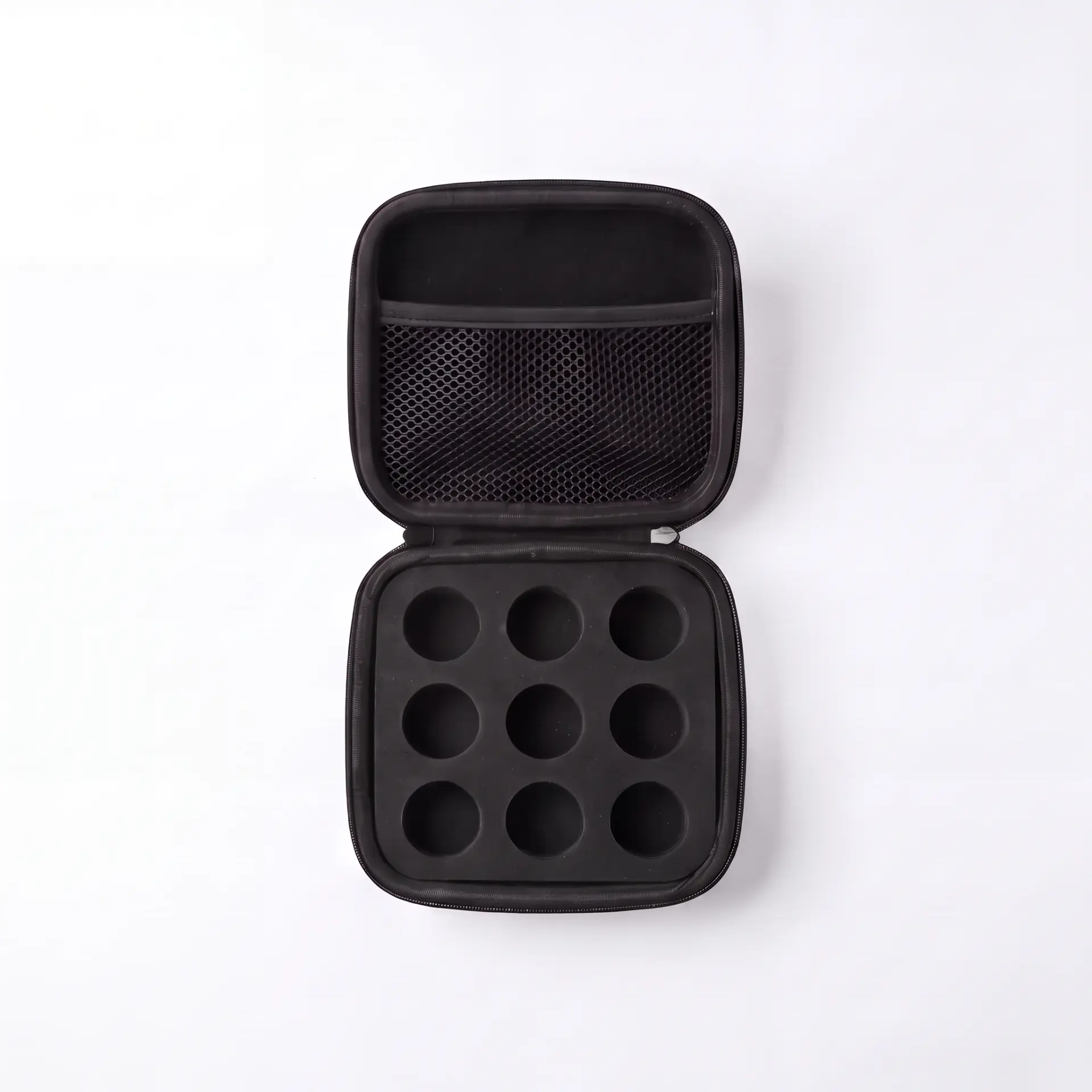 Open case from above showing nine foam slots and mesh lid pocket